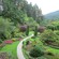 Visitors walking along paths in a sprawling garden while gardeners tend to plants
